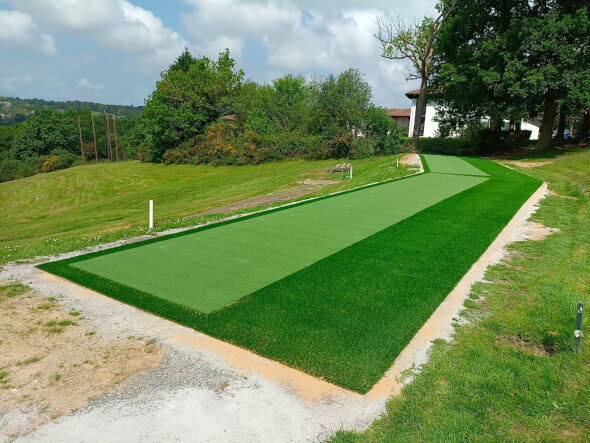 Oakley Outdoor tee line consisting of one continuous green synthetic grass strip surrounded by trees